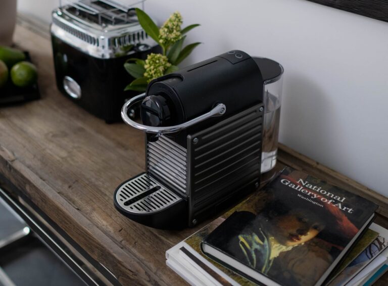 Stack of Books Beside Coffee Maker on a Wooden Table