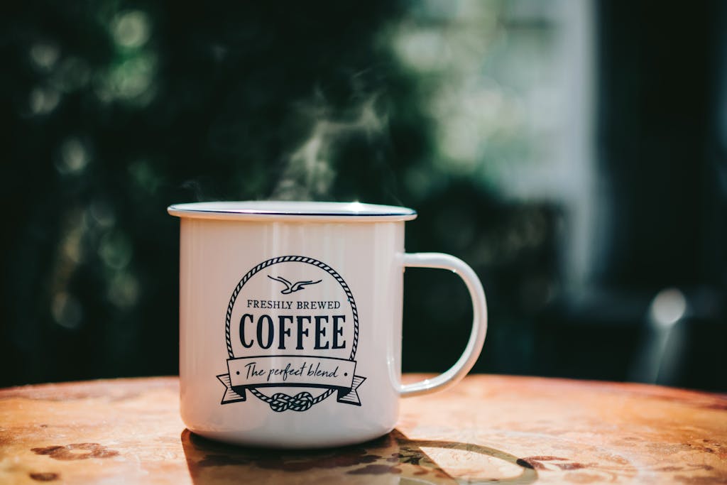 Warm coffee mug steaming on a rustic table, evoking cozy morning vibes.